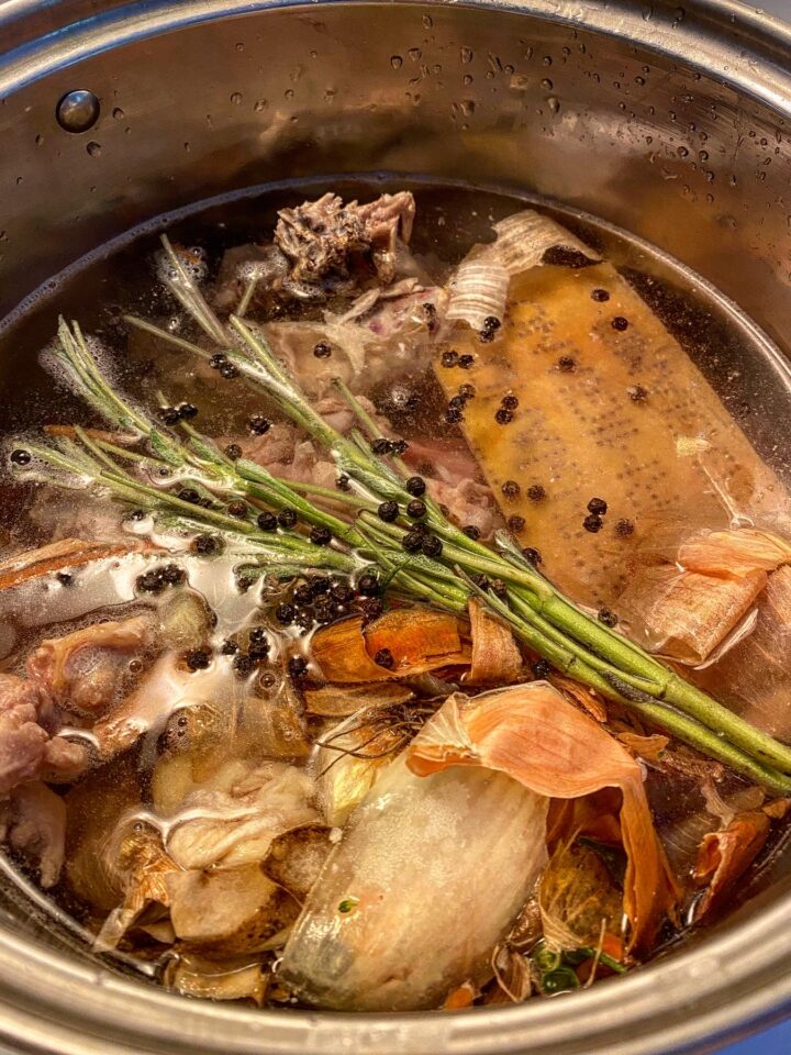 A pot filled with water and broth ingredients