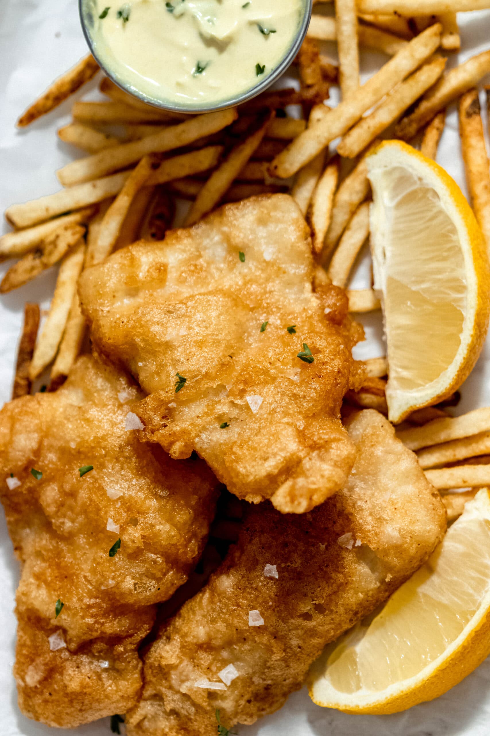 a close up shot of beer battered haddock with chips