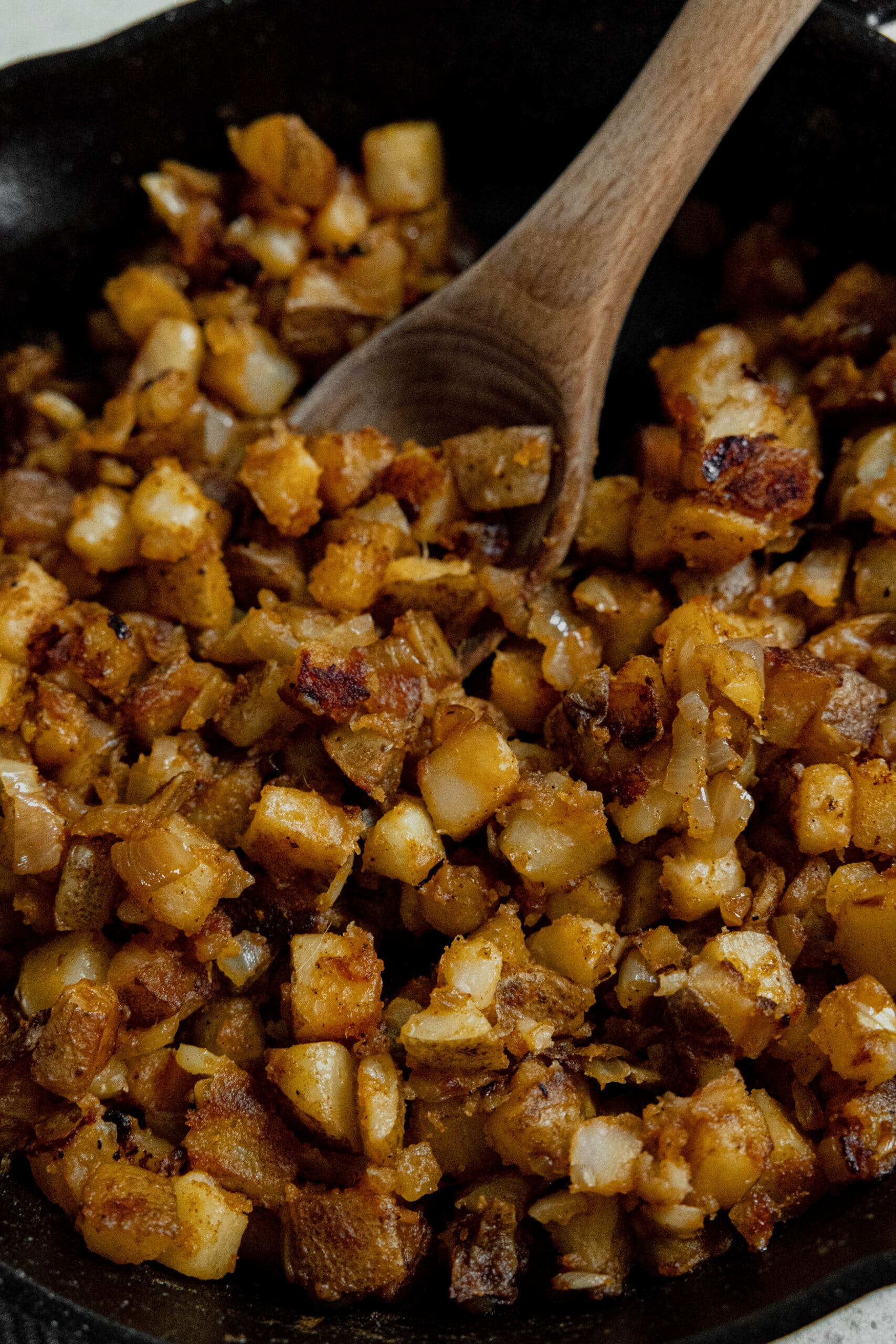 A cast iron pan filled with lots of crispy browned home fries