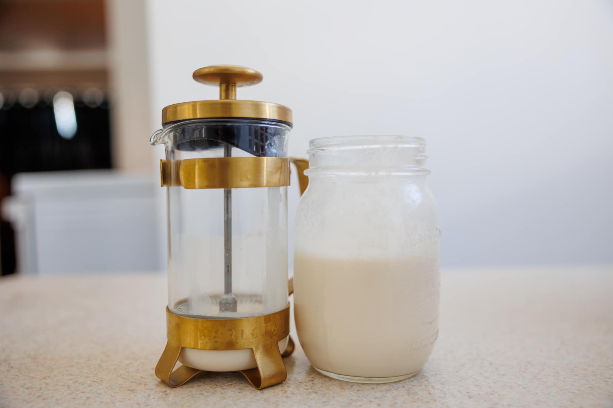 A French press and mason jar filled with sweet cream
