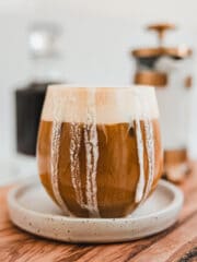 A cup of cold brew with foam dripping down the side of the cup